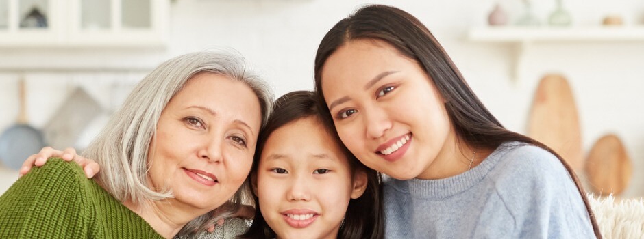 Family Of Three Women Sitting On The Couch Smiling 