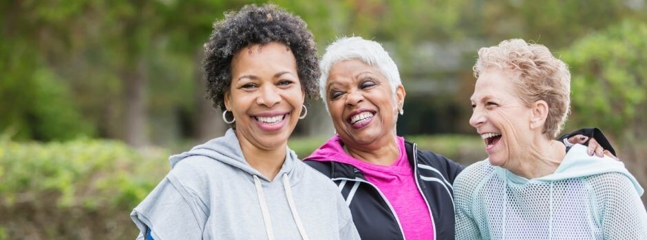 Three Older Women Grouped Together, Smiling, And Laughing