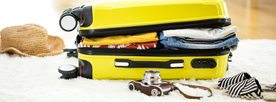 Yellow packed suitcase on wood floor ready for vacation