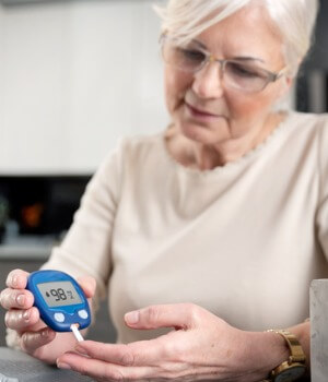 Woman checks her blood sugar level with a diabetes test strip.
