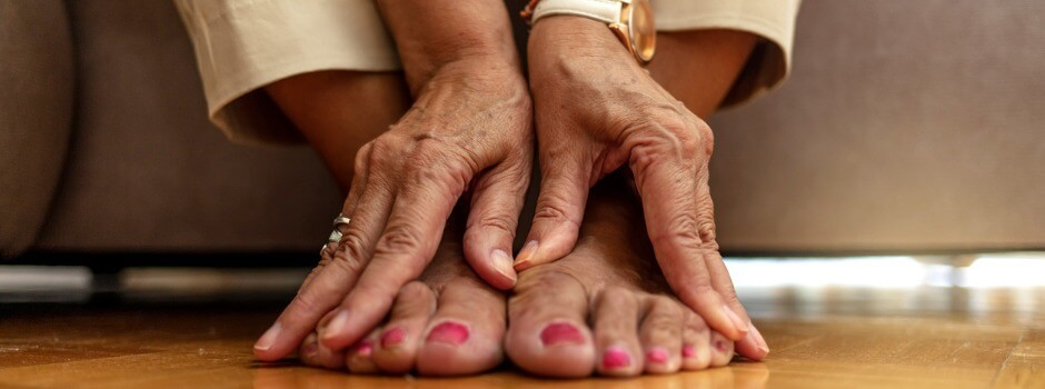 Older woman's hands massaging her feet