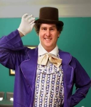 InnovAge Area Medical Director Dr. James Libbon Tips His Hat In A Purple Theater Costume