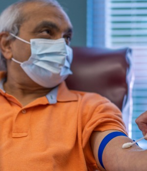 Older Man In Mask Getting Arm Swabbed