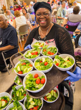 InnovAge nutritionist with healthy meals in dining room