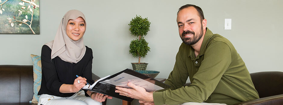 Woman And Man Social Workers Sitting And Reviewing Charts