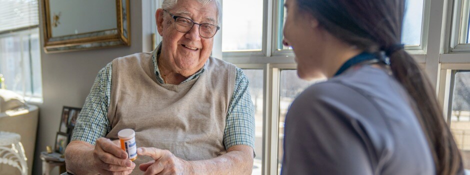 Older man and caregiver discuss his prescription