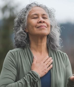 Older Adult Taking A Deep Breath With Right Hand On Chest