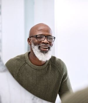 Older Male Adult Smiling Into Bathroom Mirror
